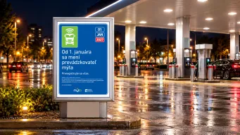 Oznam na čerpacej stanici s autami v pozadí.